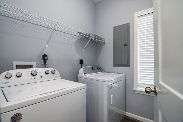 clothes washing area with electric panel, a healthy amount of sunlight, and washer and clothes dryer