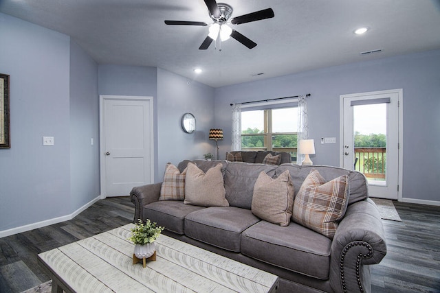 living room featuring ceiling fan and dark wood-type flooring