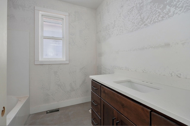 bathroom featuring vanity, tile patterned flooring, and a bathtub