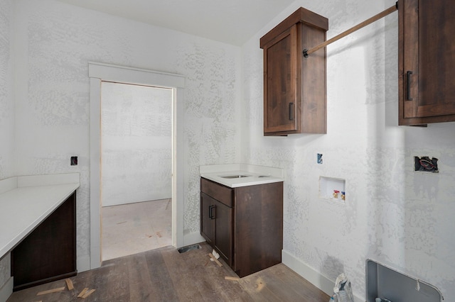 washroom with washer hookup, light hardwood / wood-style floors, and cabinets