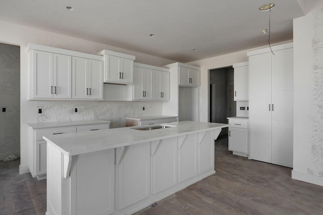 kitchen featuring white cabinetry, sink, a kitchen breakfast bar, hardwood / wood-style flooring, and a kitchen island with sink