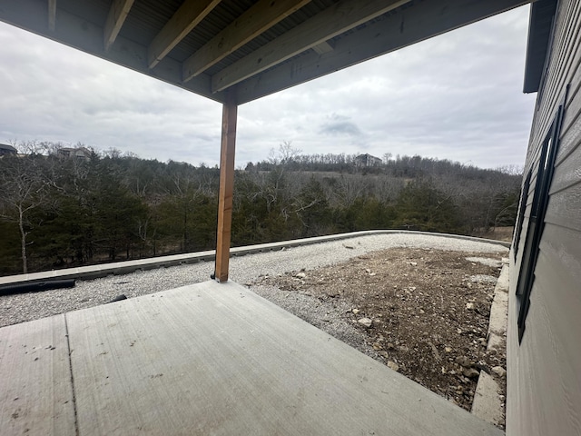 view of patio featuring a wooden deck and a forest view