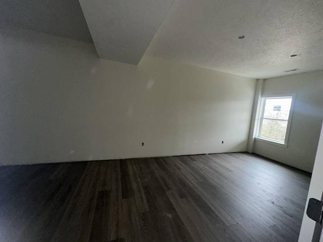 unfurnished room featuring wood-type flooring and a textured ceiling