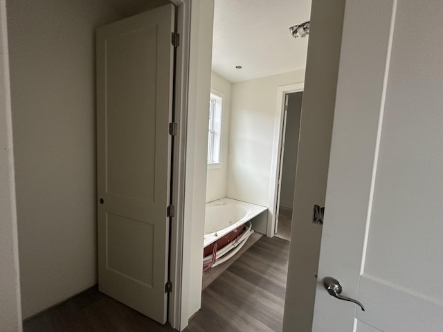 bathroom with hardwood / wood-style floors and a bath