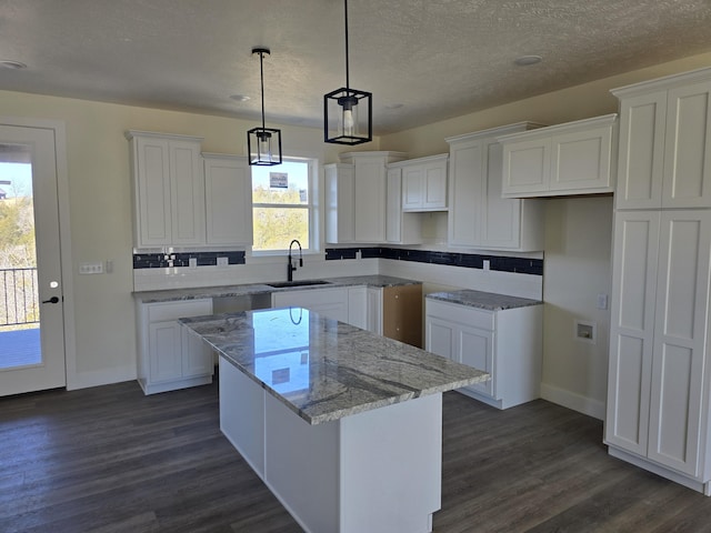 kitchen with dark wood-type flooring, white cabinets, and a center island