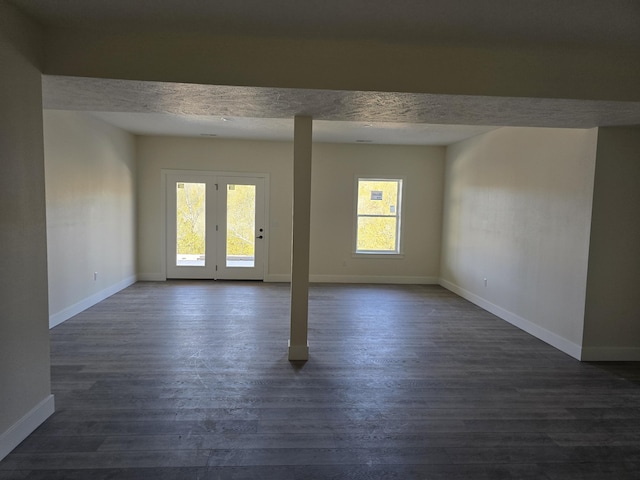 unfurnished room with dark wood-type flooring, baseboards, and a textured ceiling