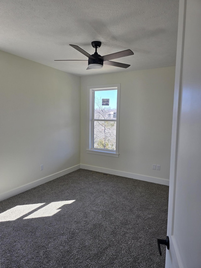 unfurnished room with dark carpet, a textured ceiling, a ceiling fan, and baseboards