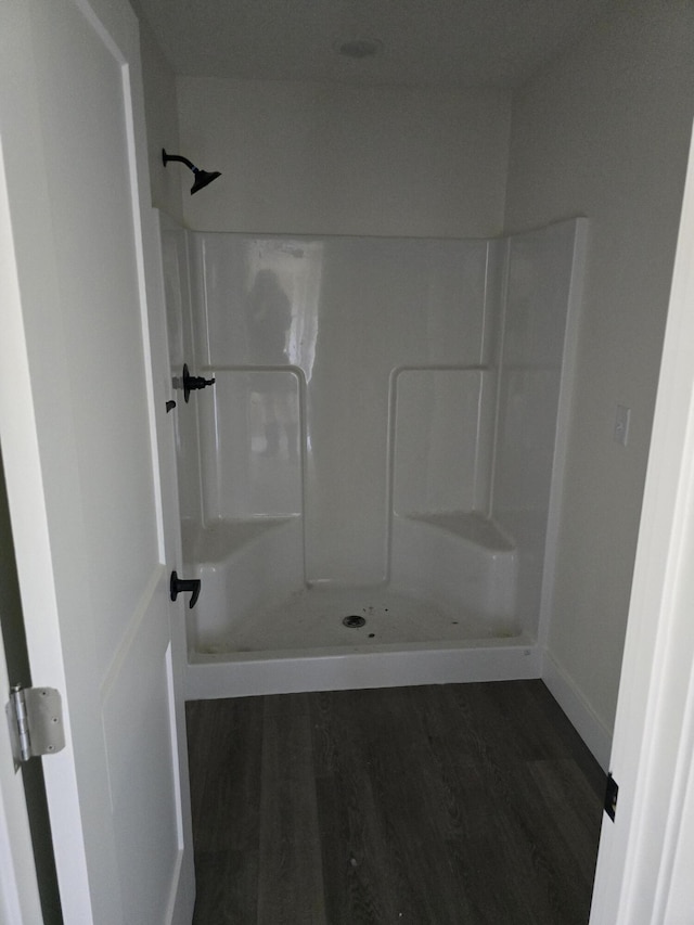 bathroom with a shower and wood finished floors