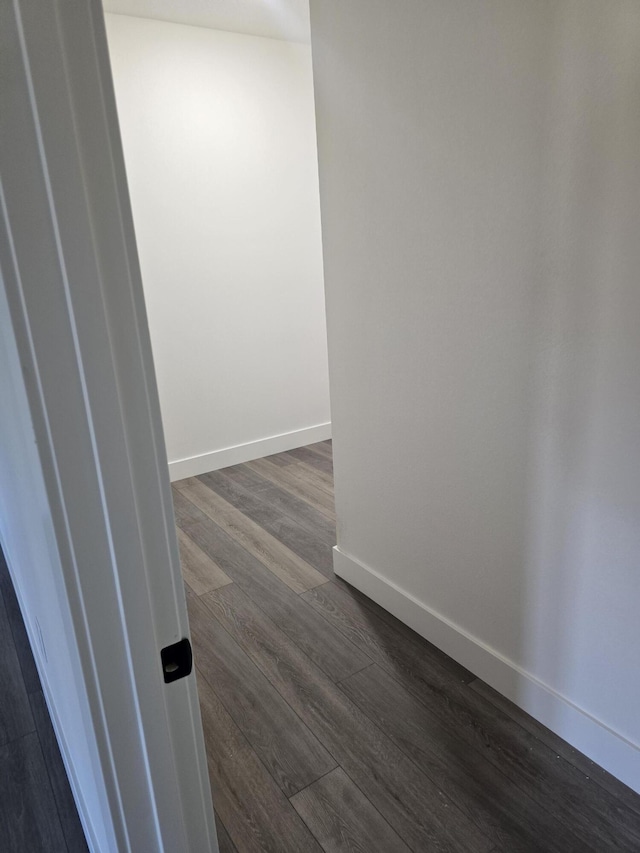 interior space featuring baseboards and dark wood finished floors