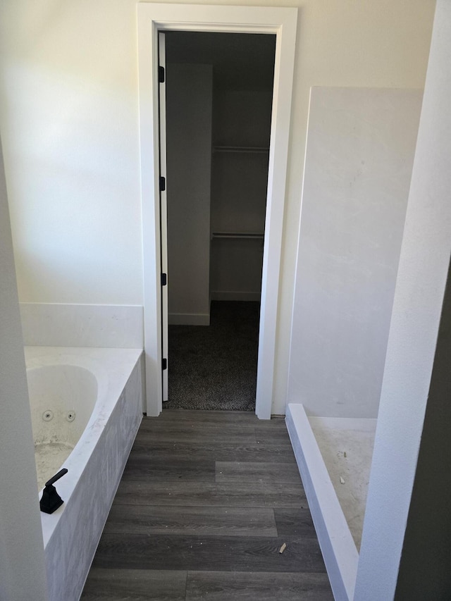 full bathroom with a jetted tub and wood finished floors