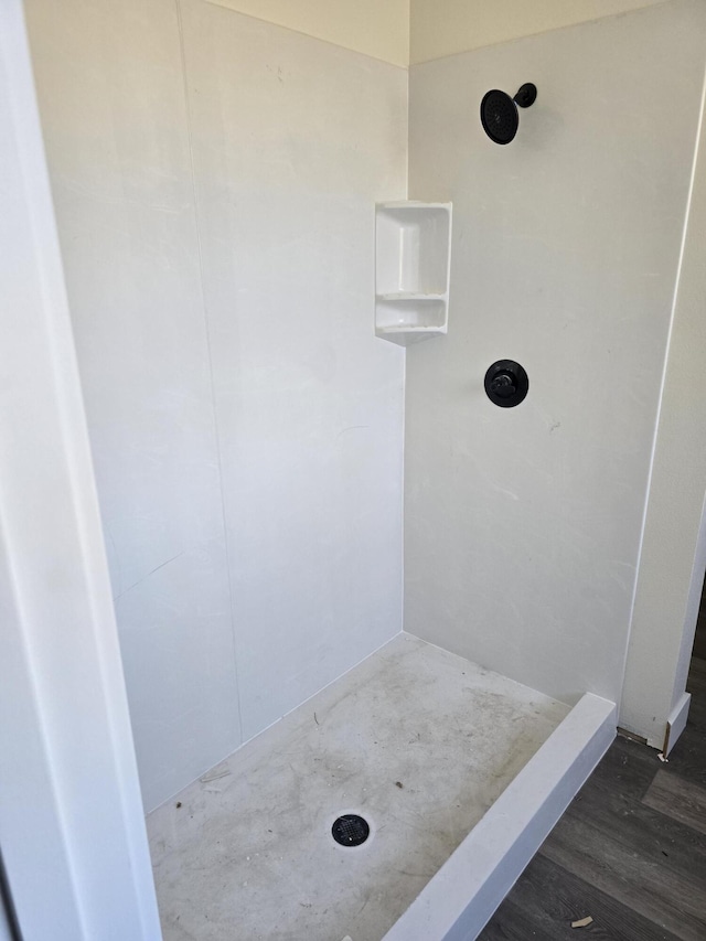 full bath with a shower and wood finished floors