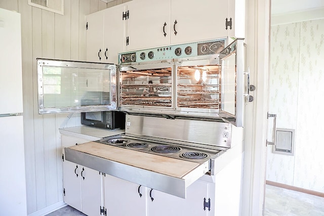 kitchen featuring white cabinets and white refrigerator