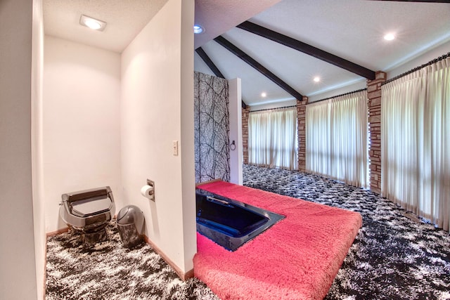 bathroom with vaulted ceiling with beams and a textured ceiling