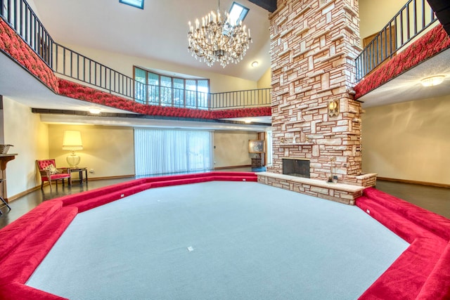 living room featuring carpet flooring, a fireplace, a towering ceiling, and a chandelier