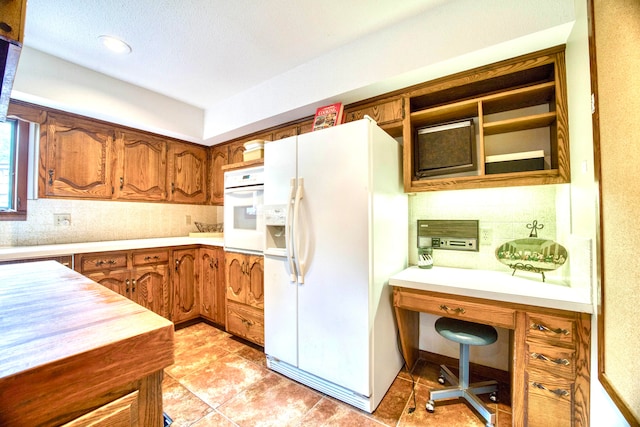 kitchen with white appliances, light tile patterned floors, and tasteful backsplash