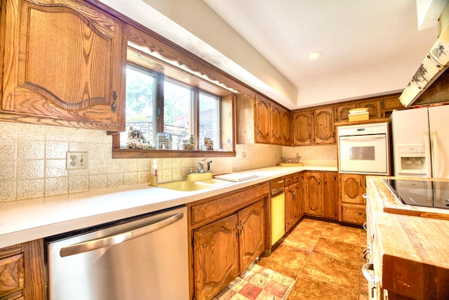 kitchen with light tile patterned floors, sink, tasteful backsplash, white appliances, and range hood