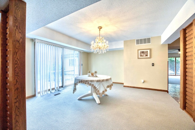 dining space featuring ceiling fan with notable chandelier, carpet flooring, and a textured ceiling