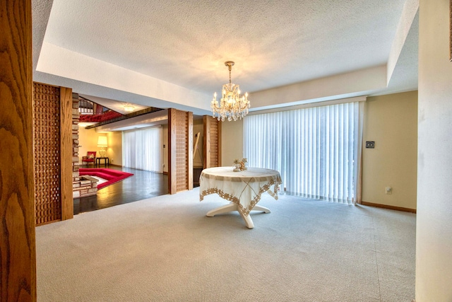 recreation room featuring a notable chandelier, hardwood / wood-style floors, a raised ceiling, and a textured ceiling