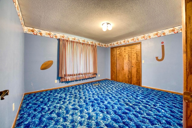 carpeted spare room with a textured ceiling