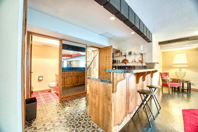 bar featuring a textured ceiling