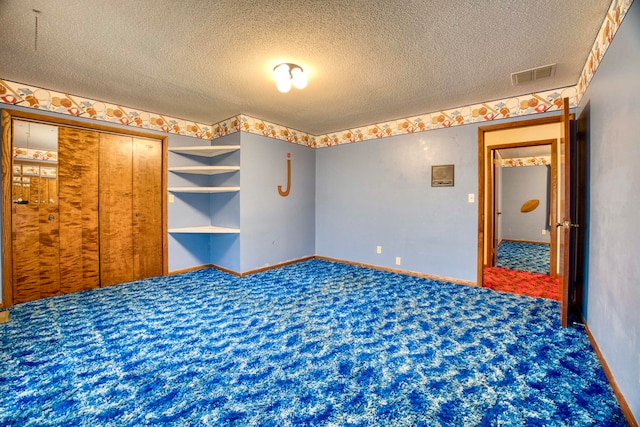 unfurnished bedroom with a closet, carpet, and a textured ceiling