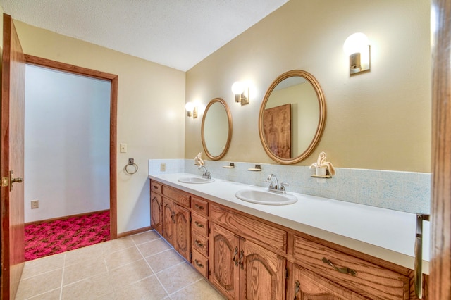 bathroom featuring tile patterned floors, vanity, and a textured ceiling