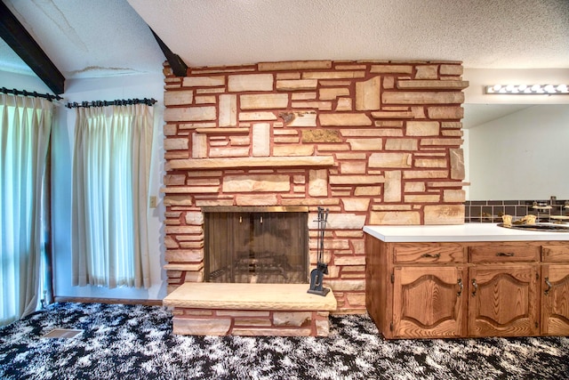 interior details featuring a fireplace, carpet, and a textured ceiling