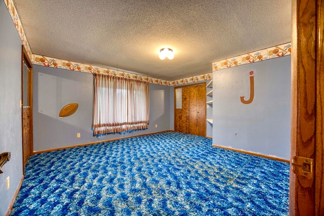 spare room featuring carpet floors and a textured ceiling