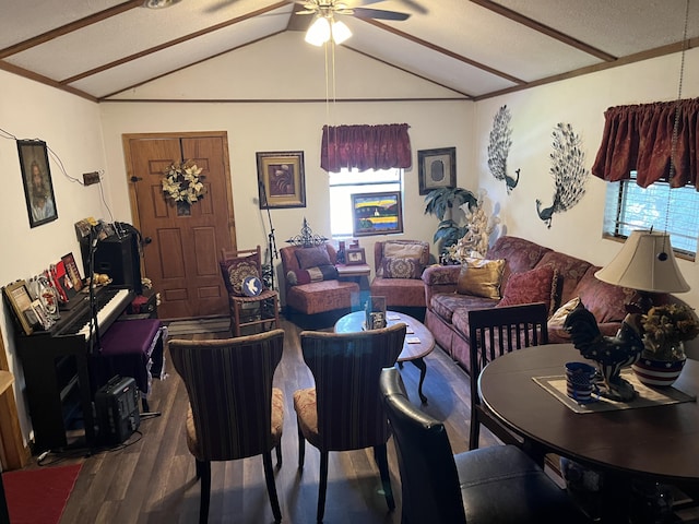 living area with vaulted ceiling, wood finished floors, a healthy amount of sunlight, and a ceiling fan