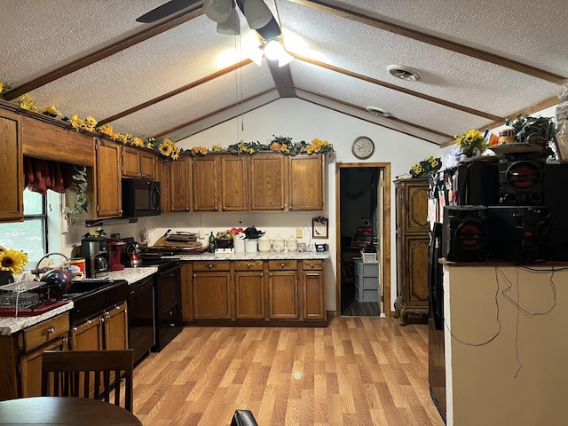 kitchen featuring light countertops, a sink, black appliances, a textured ceiling, and ceiling fan