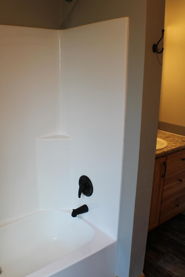 bathroom with vanity, bathtub / shower combination, and hardwood / wood-style flooring