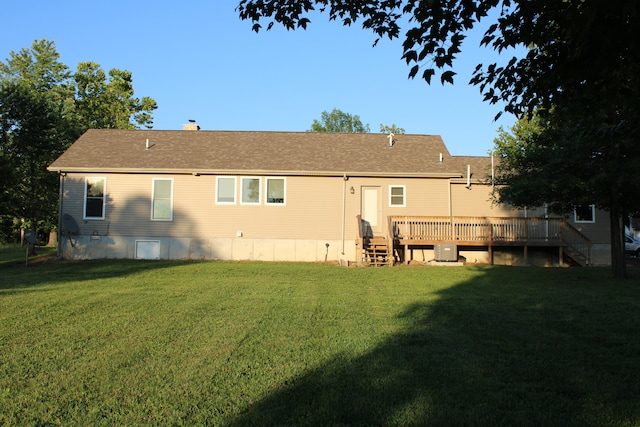 rear view of house with a wooden deck and a yard