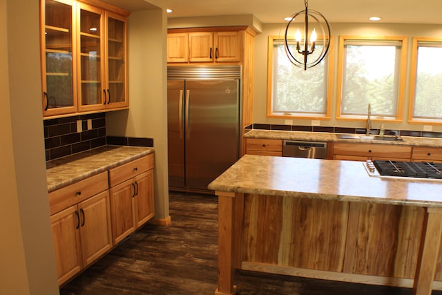 kitchen featuring decorative backsplash, pendant lighting, sink, stainless steel appliances, and dark hardwood / wood-style floors