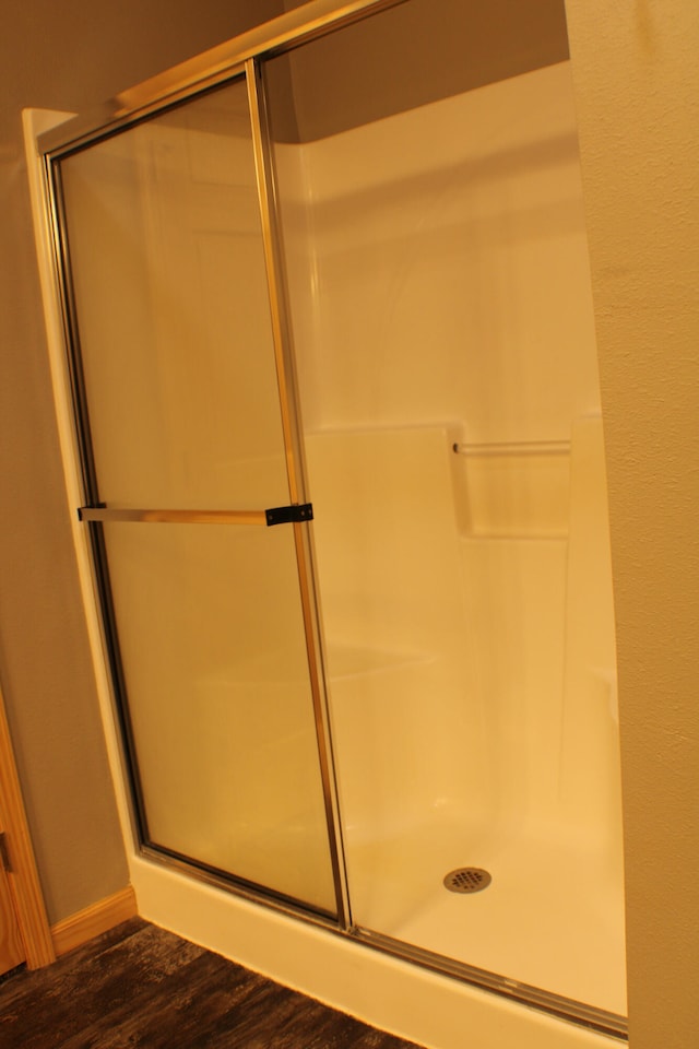 bathroom featuring hardwood / wood-style flooring and walk in shower