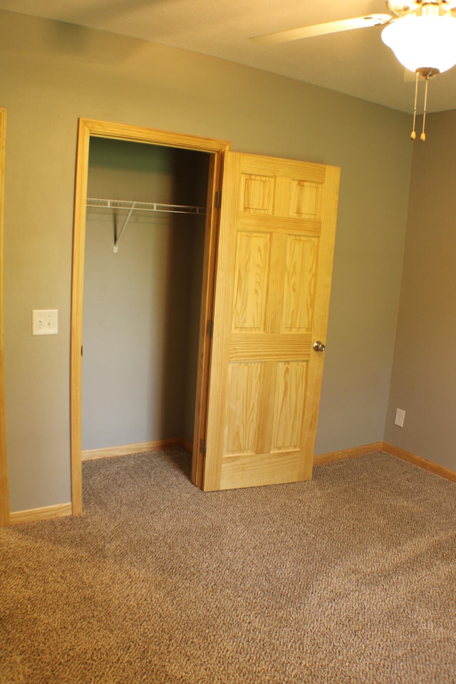 unfurnished bedroom with ceiling fan, a closet, and carpet flooring