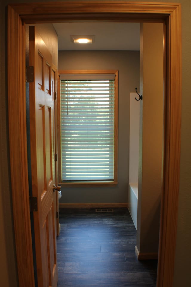 corridor with dark hardwood / wood-style flooring