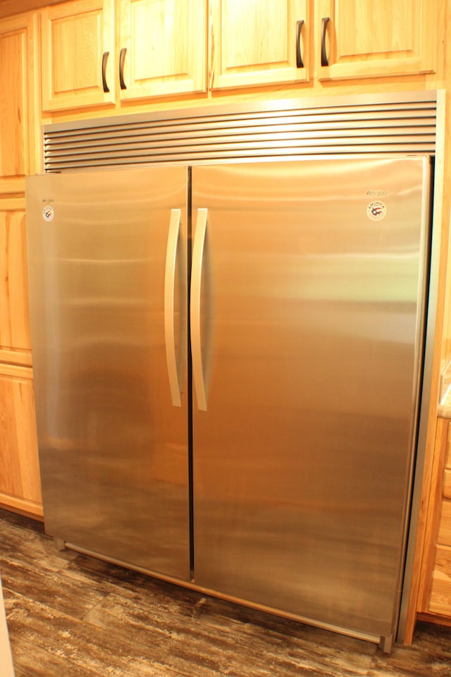 room details with light brown cabinetry, stainless steel built in refrigerator, and dark hardwood / wood-style flooring