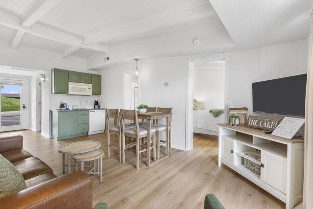 living area featuring baseboards, light wood-style flooring, and vaulted ceiling with beams