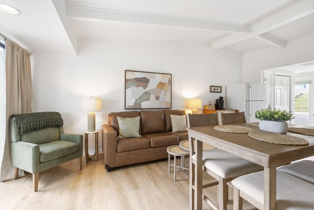 living room with light wood-type flooring and vaulted ceiling with beams