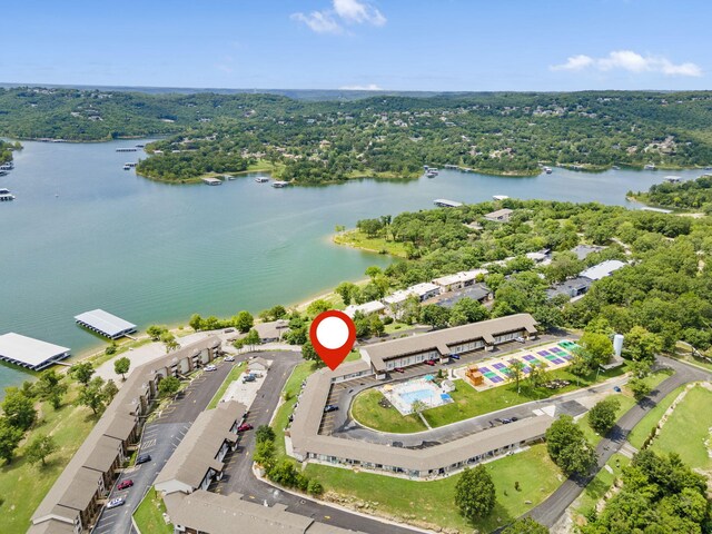 drone / aerial view featuring a forest view and a water view