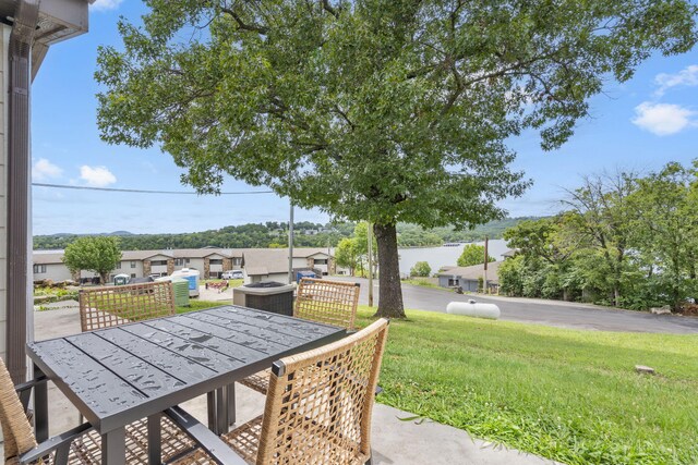 view of patio featuring a residential view, a fire pit, outdoor dining area, and central AC