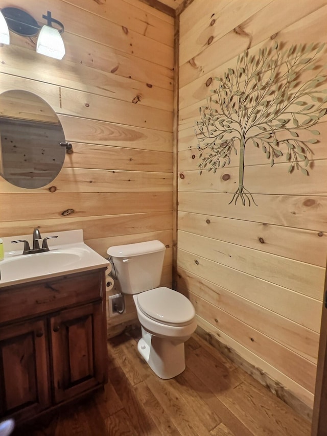 bathroom with vanity, wood walls, toilet, and wood-type flooring