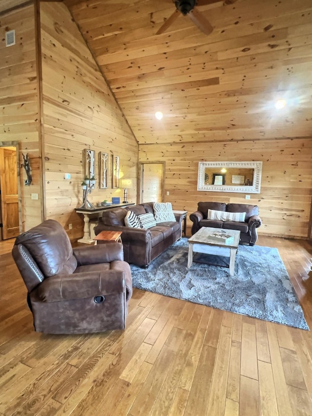 living room with wood walls, wood ceiling, light hardwood / wood-style flooring, and ceiling fan