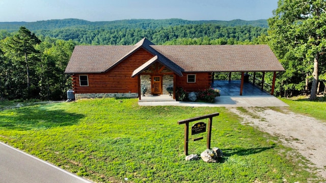 cabin with a carport and a front lawn