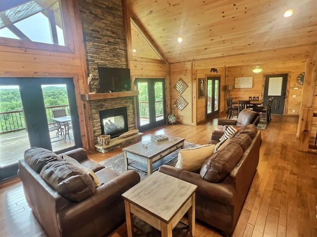 living room with wood-type flooring, wooden walls, and plenty of natural light