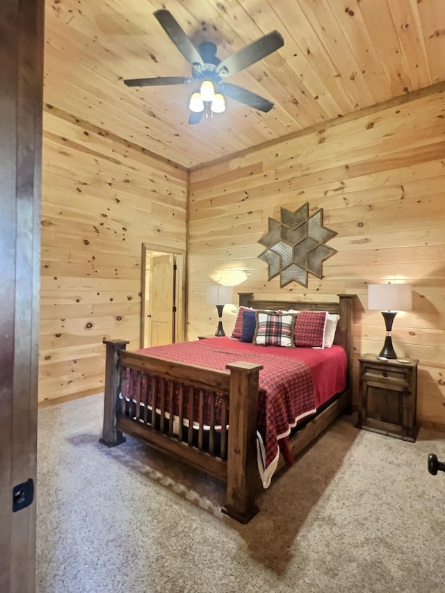 carpeted bedroom featuring wooden walls, ceiling fan, and wood ceiling