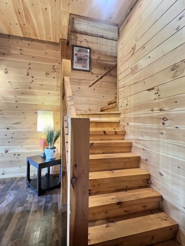 stairs featuring wood walls, wood-type flooring, and wooden ceiling