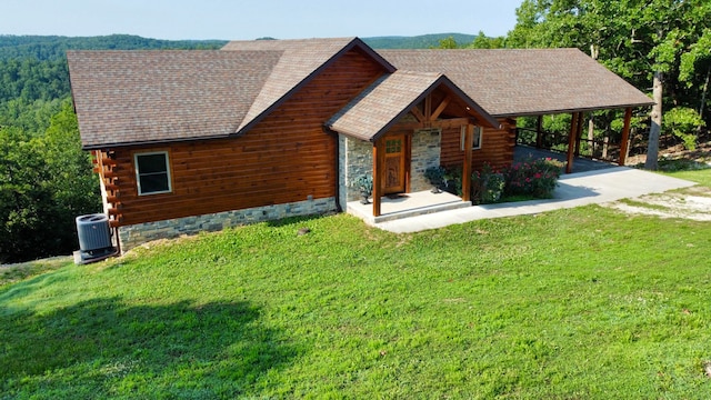 log cabin with cooling unit and a front lawn