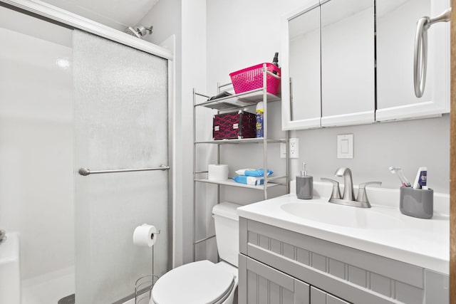 bathroom with toilet, a shower stall, and vanity