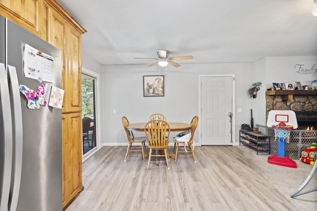 dining area with light wood finished floors, ceiling fan, and baseboards